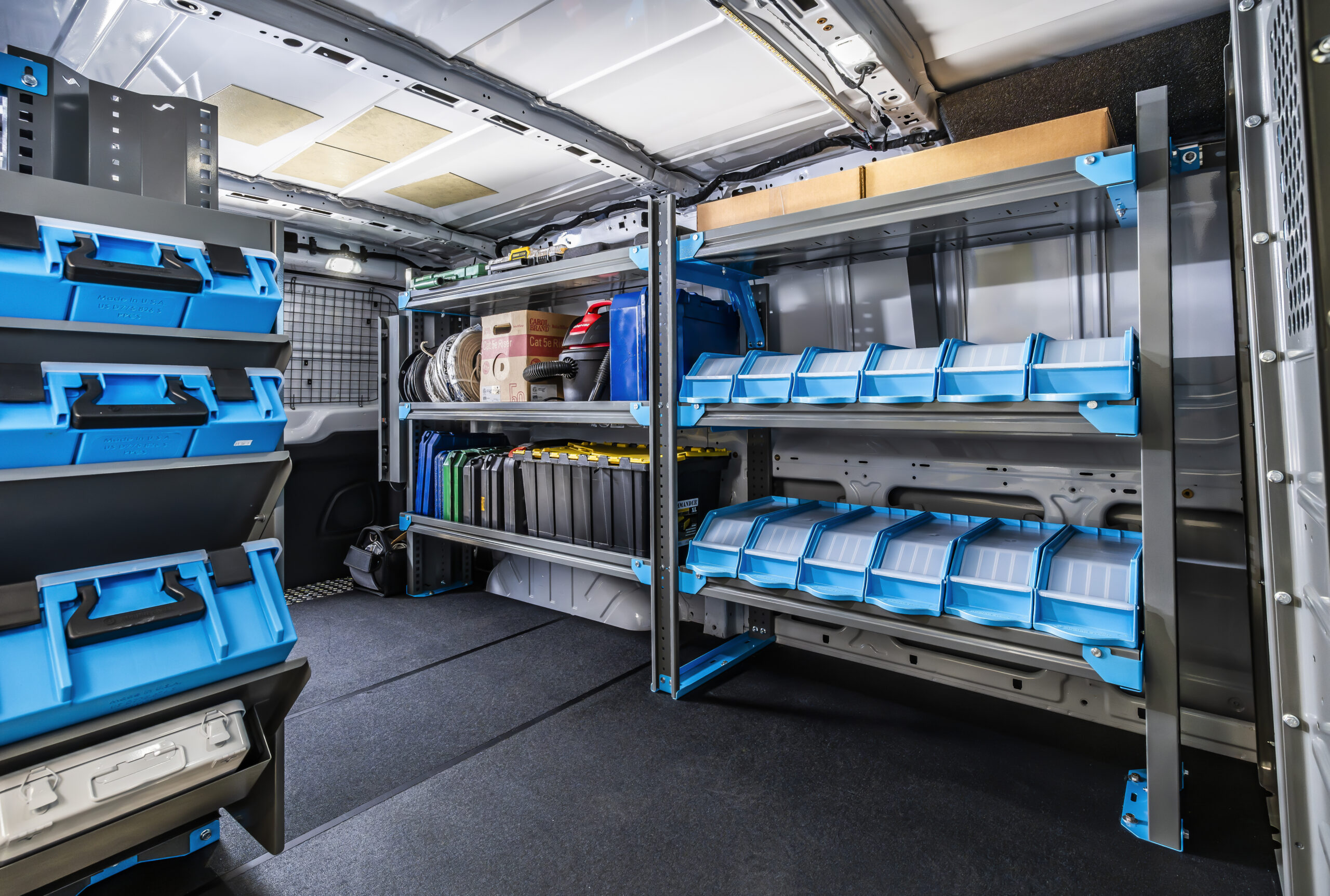 Interior shelving system inside an NV cargo van with toolboxes and parts bins.