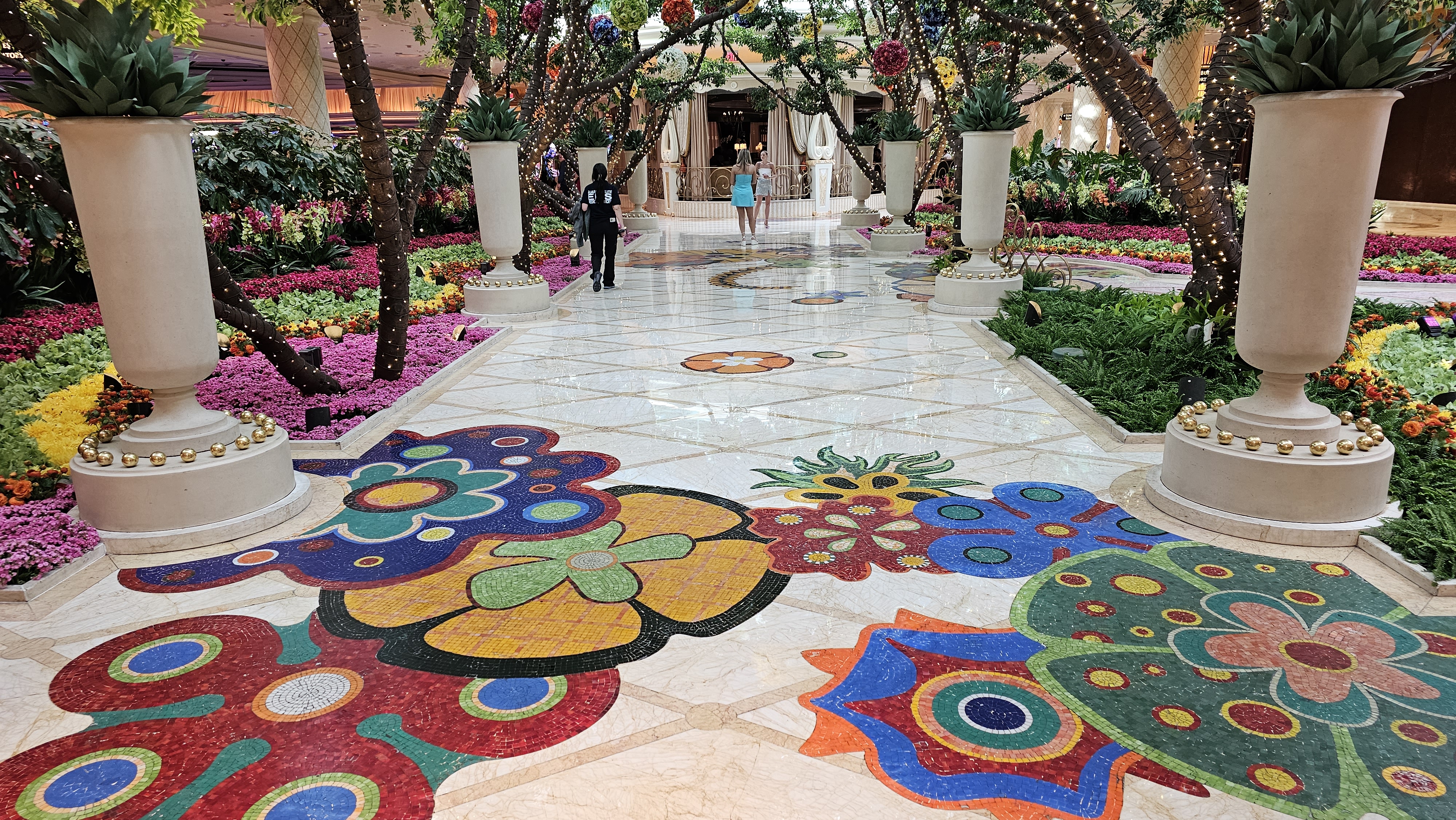 Wynn's signature floral mosaic walkway, a marble path inlaid with colorful butterfly and flower mosaics running beneath the resort's garden atrium